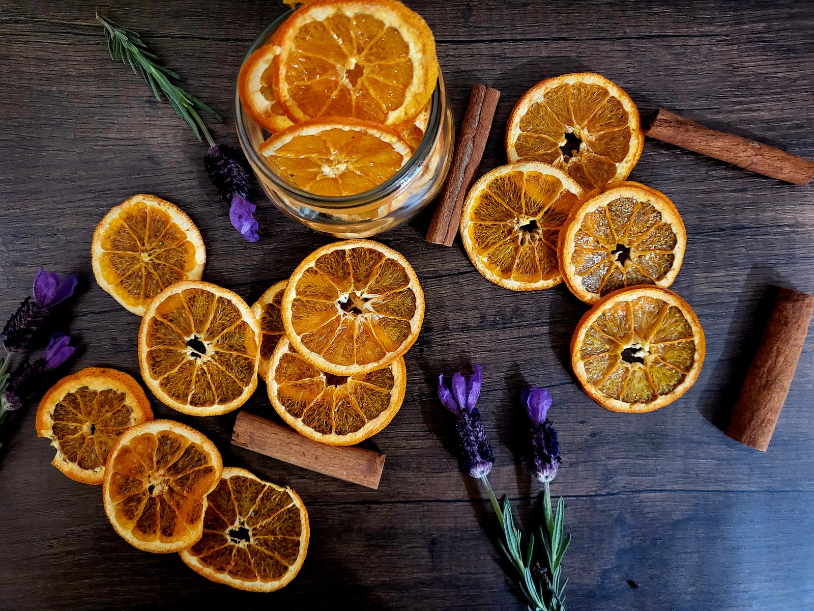 dried orange slices on a wood surface with cinnamon sticks and lavender flowers