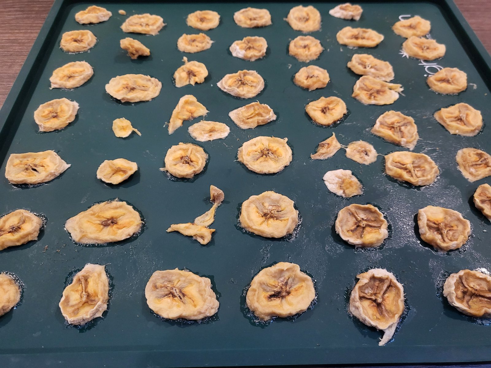 close up of dried banana slices on a silicone dehydrating tray