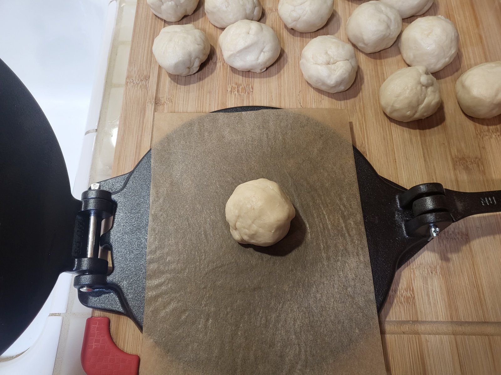 ball of flour tortilla dough on a tortilla press