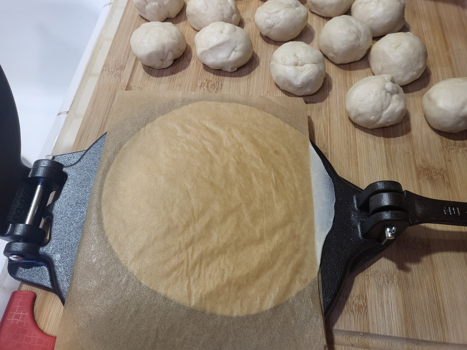 flour tortilla dough pressed in a tortilla press