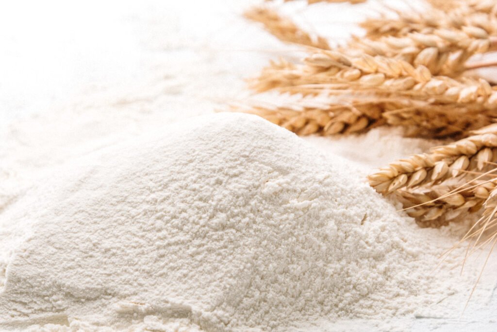 a pile of flour with wheat stalks behind it