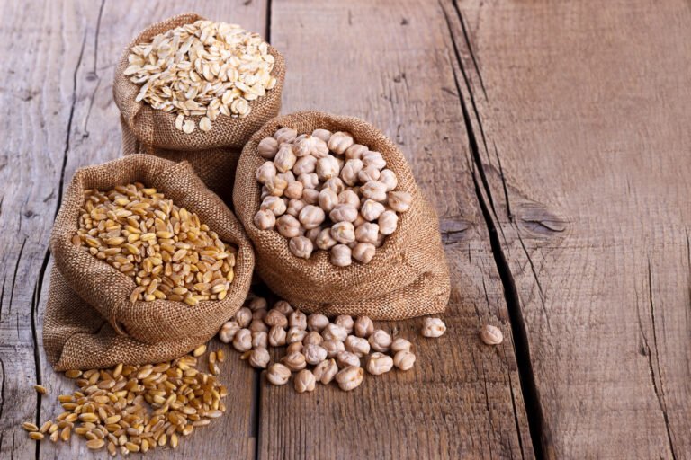 three small burlap sacks filled with chickpeas, wheat berries and rolled oats